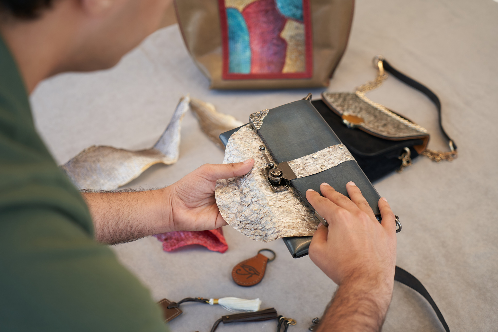 Hands examining the textured panel of a Visenleer bag