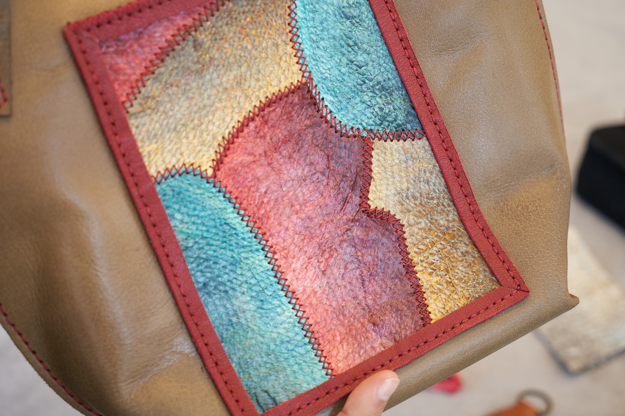 Close view of a colourful textured panel on a tan tote